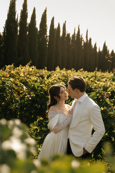 Bride and groom posing in a vineyard