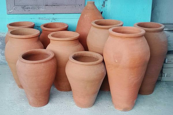 Freshly crafted Qvevri clay vessels drying in a traditional Georgian pottery workshop in Guria