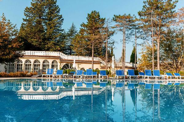 Piscina de agua mineral al aire libre con tumbonas en el Tskaltubo Spa Resort en Georgia